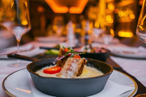 a bowl of soup with meat and vegetables on a table at NLux 10 Apartment in Kopaonik