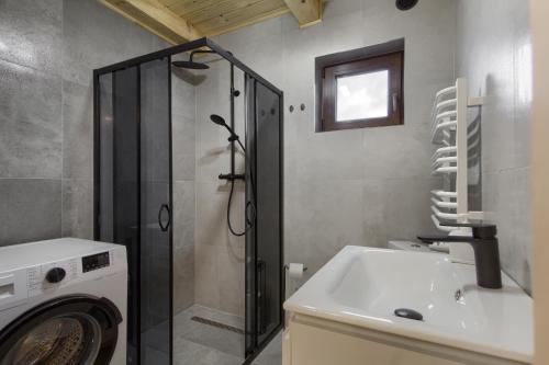 a bathroom with a washing machine and a sink at Domek Jaśkowy w Tyliczu in Tylicz
