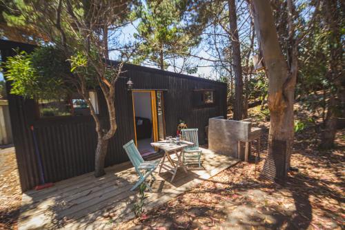 a small house with a table and chairs on a deck at La Mar Box 7 frente al Mar - Parejas in Pichilemu