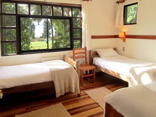 a room with two beds and a window in it at Cabañas Portal Pucon in Pucón