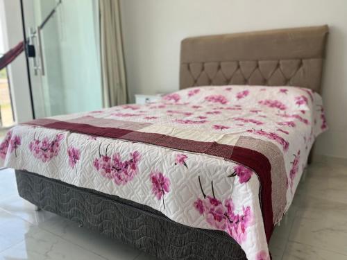 a bed with a pink and white comforter on it at VIA CARNEIROS DUPLEX in Praia dos Carneiros