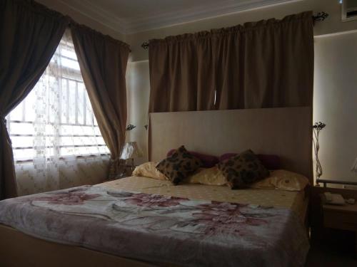 a bedroom with a large bed with a large window at URBAN CASTLE SUITES Gwarimpa in Abuja