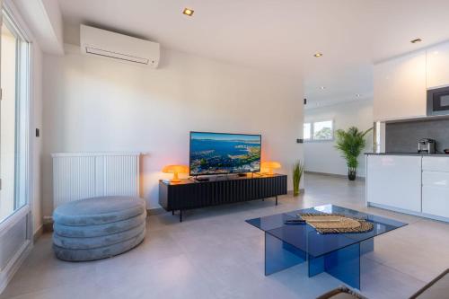 - un salon avec une grande télévision murale dans l'établissement 06AZ - Apartment with terrace - 10min from Palais, à Cannes