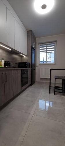 a kitchen with white cabinets and a table in it at Solanki Central Apart in Inowrocław
