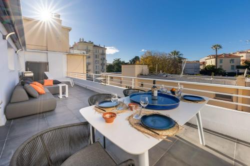 d'un balcon sur le toit avec une table et des chaises. dans l'établissement 06AZ - Apartment with terrace - 10min from Palais, à Cannes