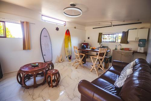 a living room with a couch and surfboards on the wall at La Mar Box 7 frente al Mar - Parejas in Pichilemu