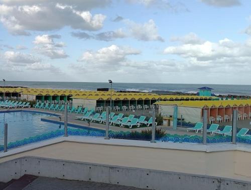 een resort met een zwembad en stoelen en de oceaan bij Zit Flat in Mar del Plata