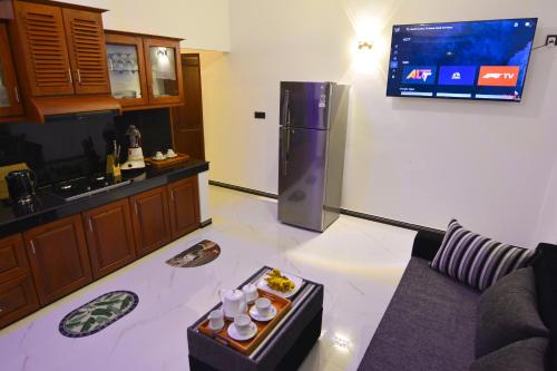 a kitchen with a couch and a tv on the wall at Monkey Island Hotel in Hikkaduwa