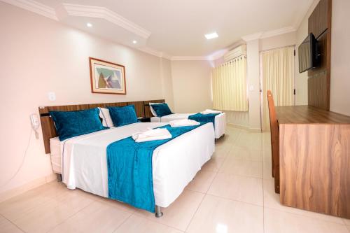 een hotelkamer met 2 bedden en een flatscreen-tv bij Império Romano Thermas - BVTUR in Caldas Novas