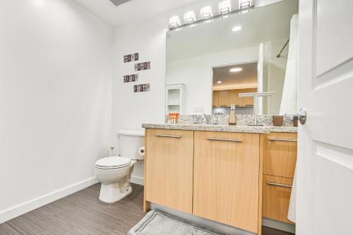 a bathroom with a toilet and a sink and a mirror at High-End San Diego Condo with Pool and Rooftop Access in San Diego