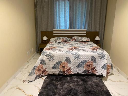 um quarto com uma cama com colcha floral em Apt. Luxo Cond.Mar de Conchas no Rio de Janeiro