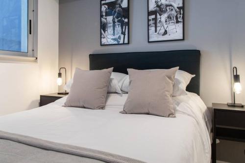 een slaapkamer met een wit bed met drie foto's aan de muur bij Enebro Beautiful Apartment in Buenos Aires