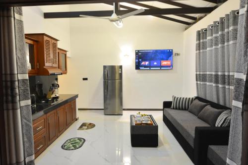 a living room with a couch and a refrigerator at Monkey Island Hotel in Hikkaduwa