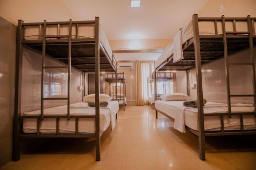 um quarto com 3 beliches e lençóis brancos em Drop Inn Hostels em Colombo