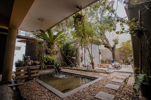 a garden with a pond in the middle of a yard at Drop Inn Hostels in Colombo