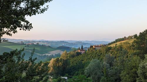 a view of a valley with trees and houses on a hill at Charming Barolo Wine Loft in Monforte dʼAlba