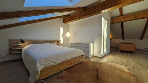 a bedroom with a large bed in a room with wooden ceilings at Charming Barolo Wine Loft in Monforte dʼAlba