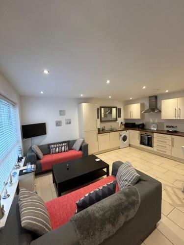 a living room with two couches and a kitchen at Ballycastle, Beachside Apartment in Ballycastle