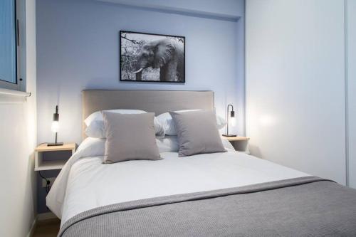 ein Schlafzimmer mit einem großen weißen Bett mit zwei Lampen in der Unterkunft Lavanda Beautiful Apartment in Buenos Aires