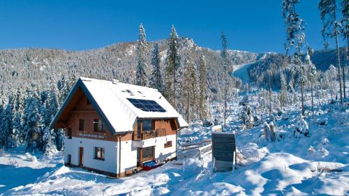 a house with snow on the roof in the mountains at Villa pod hviezdami Jasná in Demanovska Dolina
