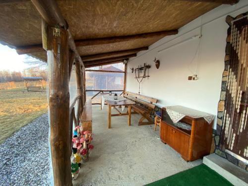 une chambre avec une table et un banc sur une terrasse dans l'établissement Cabana Bradu Moșului, 