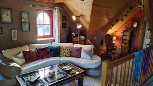 ein Wohnzimmer mit einem Sofa und einem Tisch in der Unterkunft Gite Esprit du Monde in Kervignac