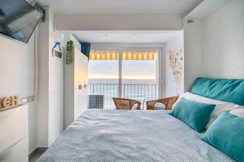 ein Schlafzimmer mit einem großen Bett und einem großen Fenster in der Unterkunft Loft beach blue in Platja  d'Aro