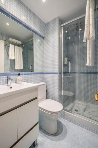 a bathroom with a toilet and a shower and a sink at Loft beach blue in Platja d'Aro