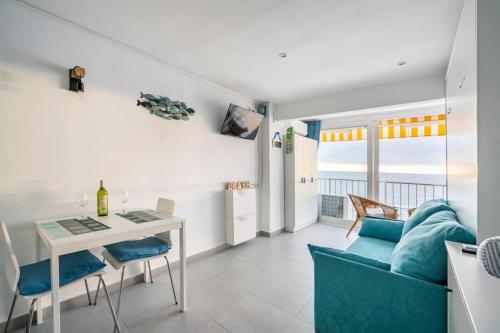 ein Wohnzimmer mit einem Tisch und einem blauen Sofa in der Unterkunft Loft beach blue in Platja  d'Aro
