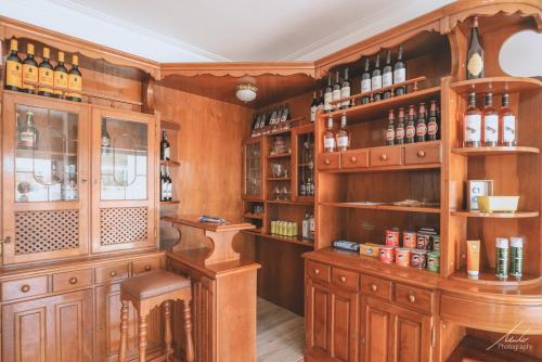 una cocina con armarios de madera y estanterías con botellas de vino en Guesthouse Beach Break, en Peniche
