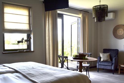 Schlafzimmer mit einem Bett, einem Tisch und einem Fenster in der Unterkunft Bedje in de polder in Montfoort