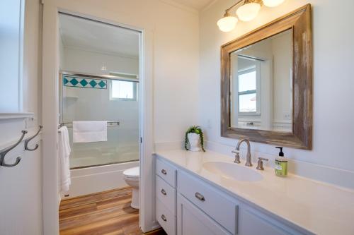 a bathroom with a sink and a mirror and a toilet at Beachfront Bandon Vacation Rental with Ocean View! in Bandon