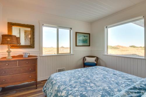 a bedroom with a bed and a dresser and two windows at Beachfront Bandon Vacation Rental with Ocean View! in Bandon