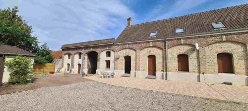 an old brick building with arches and windows at maison de vacances in Quend