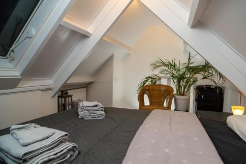 a attic bedroom with a bed with towels on it at Sfeervol verblijf nabij centrum Almelo in Almelo