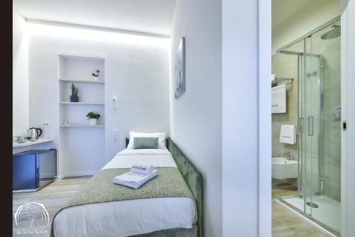 een kleine slaapkamer met een bed en een douche bij FORESTERIA GUESTHOUSE CA' DEI BACHITT in Lierna