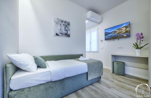 a bedroom with a bed with white walls at FORESTERIA GUESTHOUSE CA' DEI BACHITT in Lierna