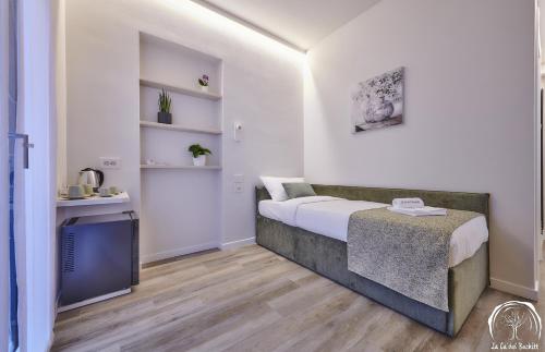 a small bedroom with a bed and a table at FORESTERIA GUESTHOUSE CA' DEI BACHITT in Lierna