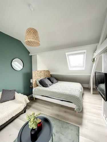 une chambre avec un lit, un canapé et une table dans l'établissement Coeur de ville, T2 cosy & élégant, à Dunkerque