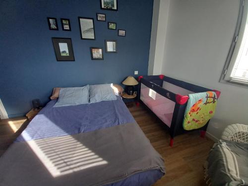 a bedroom with two beds and a blue wall at La désirée à Noirmoutier in Noirmoutier-en-l'lle