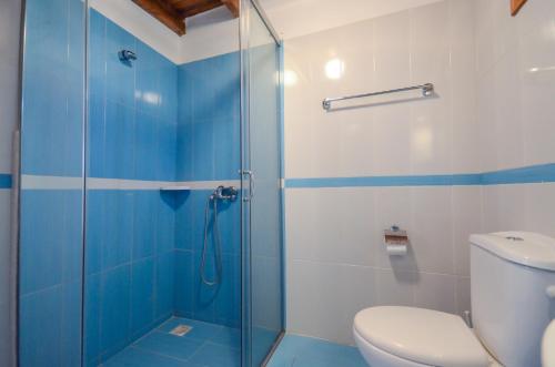 a bathroom with a toilet and a glass shower at Infinity Apartments in Naxos Chora