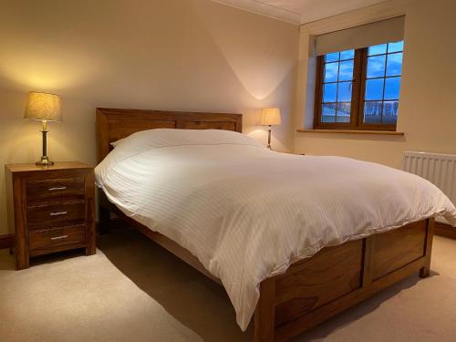- une chambre avec un grand lit et une fenêtre dans l'établissement Red House Farm Cottages, à Beverley