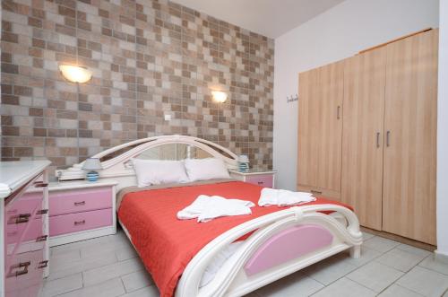 a small bedroom with a bed with a red blanket at Infinity Apartments in Naxos Chora