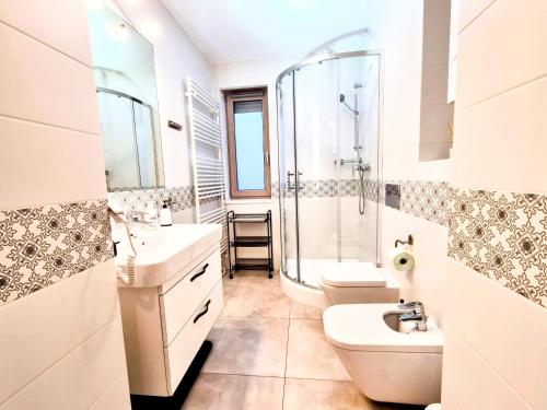 a bathroom with a sink and a toilet and a shower at Apartament Turkusowy z ogrodem w Mielnie nad morzem in Mielno