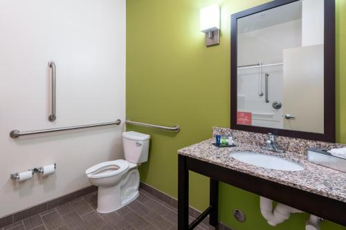 a bathroom with a toilet and a sink and a mirror at Sleep Inn & Suites Harbour Pointe in Brandermill