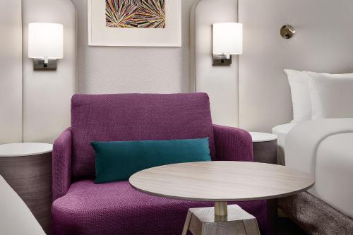 a living room with a purple chair and a table at Crowne Plaza Atlanta Perimeter at Ravinia by IHG in Atlanta