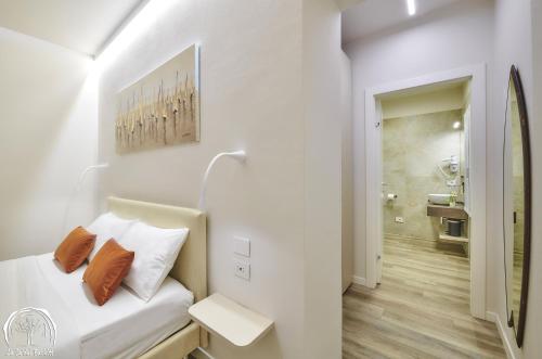 a white bedroom with a bed and a bathroom at FORESTERIA GUESTHOUSE CA' DEI BACHITT in Lierna