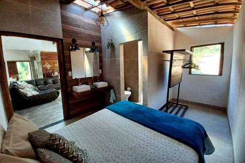 a bedroom with a bed and a living room at Casa Rustica na Chapada Diamantina - Recanto Morro do Sobrado in João Pessoa