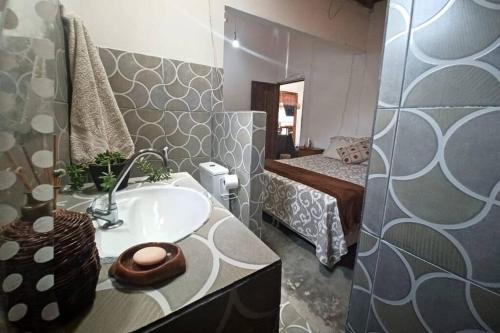 a bathroom with a sink and a bedroom with a bed at Casa Rustica na Chapada Diamantina - Recanto Morro do Sobrado in João Pessoa