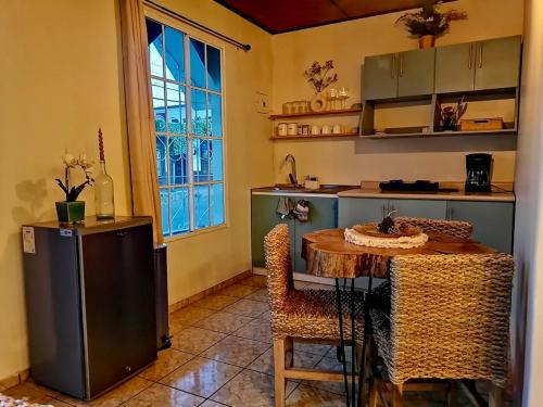 a kitchen with a table and some chairs in a room at Orquídea Loft in Juayúa